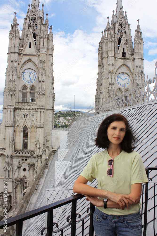 mid age woman standing on top of cathedral in Quito