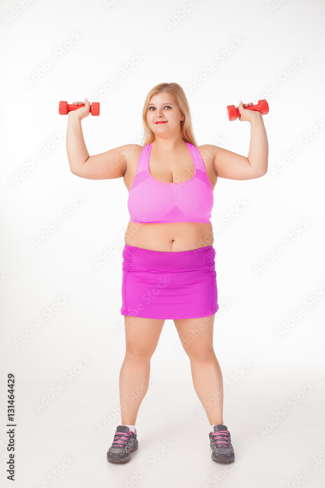 Beautiful overweight woman doing exercises with dumbbells Beautiful overweight woman doing exercises with dumbbells