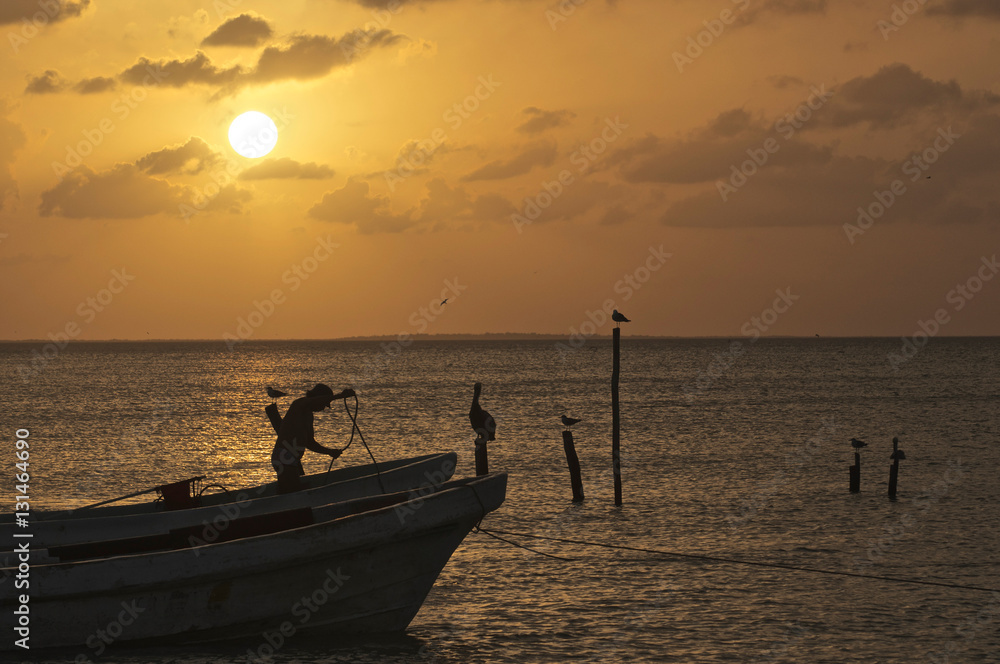 Setting sun on water with silhouette of fisherman
