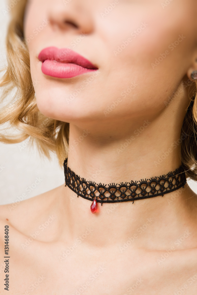 Beautiful woman showing her neck with a choker on it