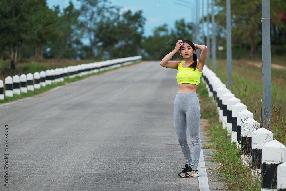 Fit woman walking on road in park