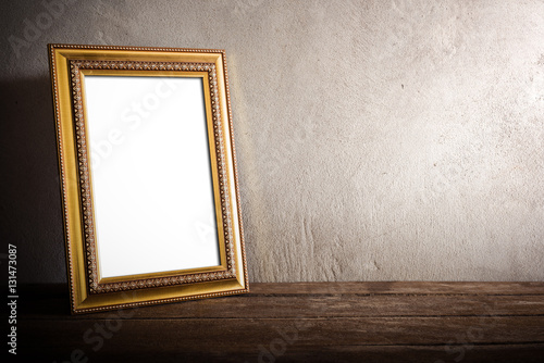 luxurious photo frame on wooden table over grunge background