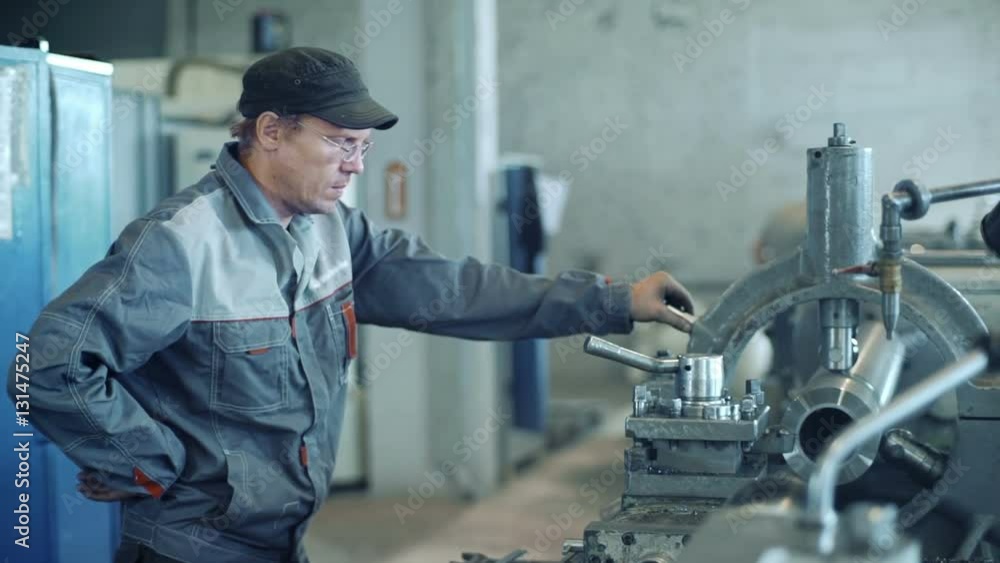 Industrial worker operating milling machine Industrial worker operating milling machine
