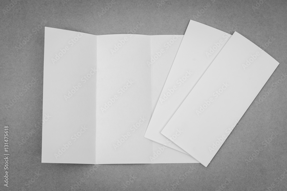 Trifold white template paper on gray background . Trifold white template paper on gray background .