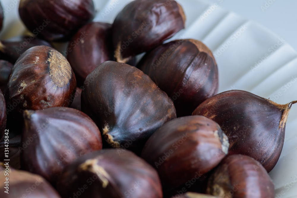 Obraz premium Chestnut fruits on light background selective focus