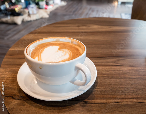 Delicious hot coffee in white cup on wooden table