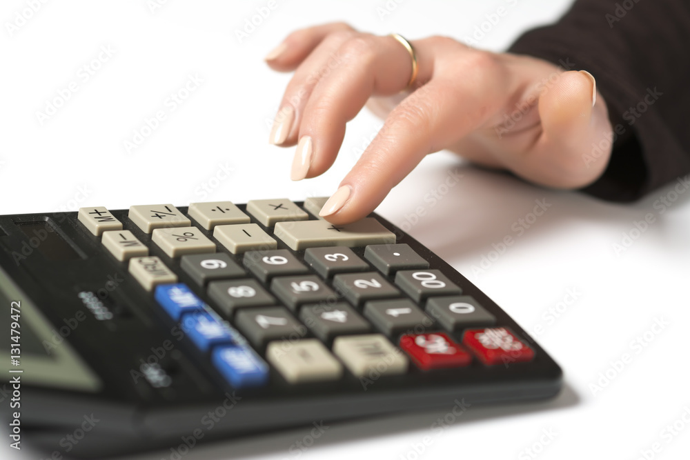 Women's hand presses plus on a calculator Women's hand presses plus on a calculator