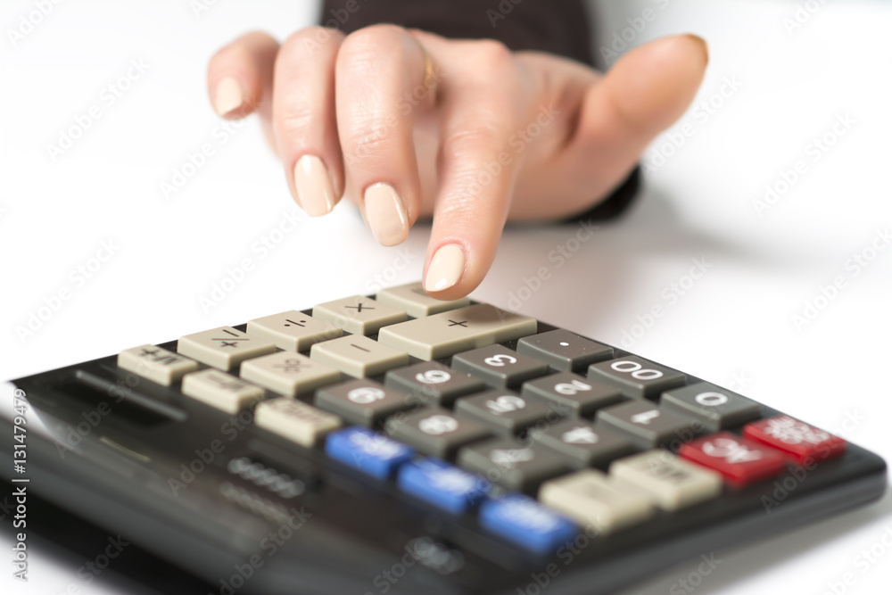 Finger presses the plus button on the calculator Finger presses the plus button on the calculator