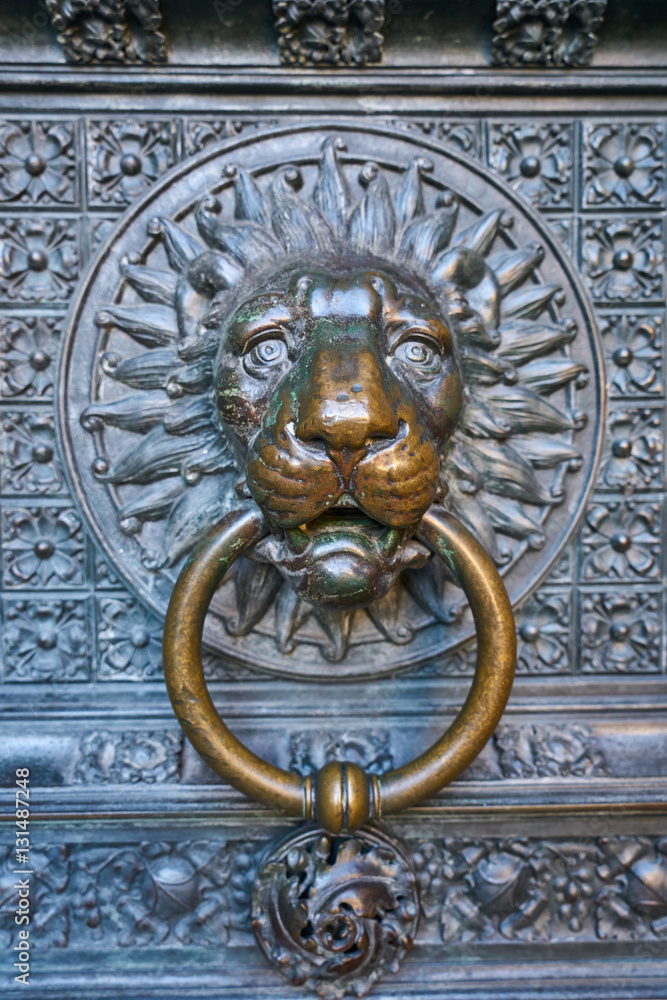 beautiful bronze knocker in the shape of lion head at  the gate of the Cologne Cathedral, the most famous church in Germany, the world cultural heritage of UNESCO