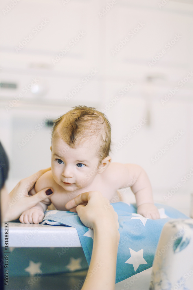 small child learns to help parents keep his head. baby lying on a blue diaper in a star. parental support. small child learns to help parents keep his head. baby lying on a blue diaper in a star. parental support.