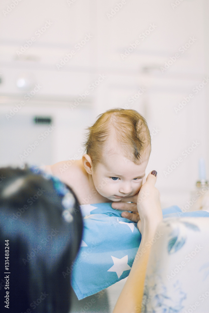small child learns to help parents keep his head. baby lying on a blue diaper in a star. parental support. small child learns to help parents keep his head. baby lying on a blue diaper in a star. parental support.