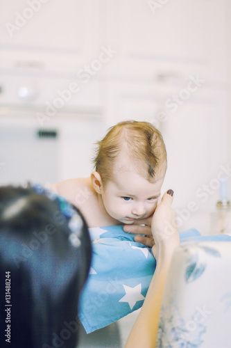 small child learns to help parents keep his head. baby lying on a blue diaper in a star. parental support.