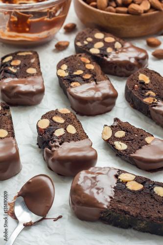 Homemade dark chocolate biscotti cookies with almonds, covered with melted chocolate, vertical