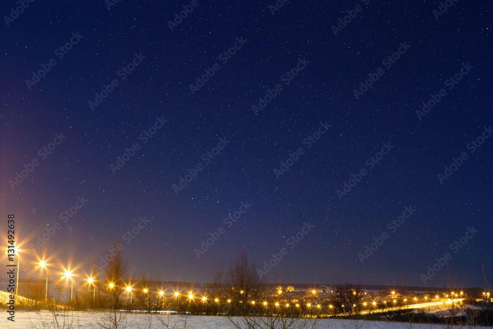 Car highway with star sky, lit by lanterns. Night landscape in t