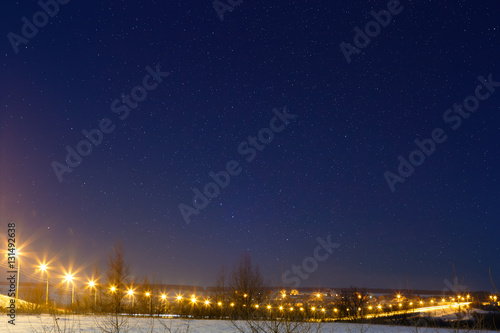 Car highway with star sky, lit by lanterns. Night landscape in t