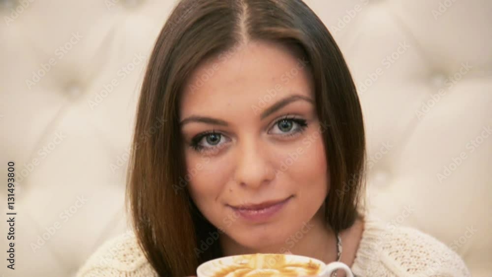 Brunette young woman in cafe drinking coffee Brunette young woman in cafe drinking coffee