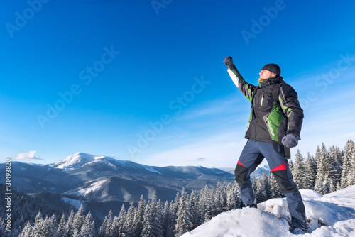 Traveler in the mountains in winter hand up on a sunny day