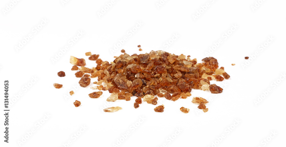 Pinch of brown caramel sugar spilled on white Pinch of brown caramel sugar spilled on white