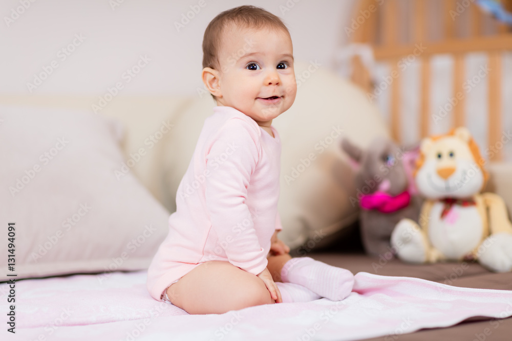Such a happy little baby girl / Beautiful cute soft baby girl sitting on bed Such a happy little baby girl / Beautiful cute soft baby girl sitting on bed