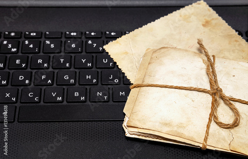 Old photos on a laptop keyboard. Creating an electronic family a