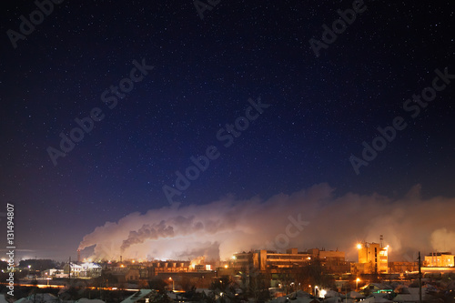Night starry sky over an industrial area of the city. Landscape