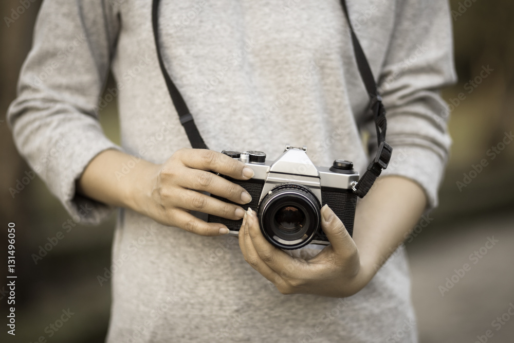 Vintage women photographer hand holding retro camera, soft focus