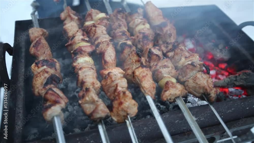 Pork shashlik fried on a skewer on the grill in the backyard in the winter. Pork shashlik fried on a skewer on the grill in the backyard in the winter.
