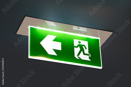 green emergency exit sign showing the way to escape.