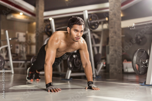 Fototapeta Naklejka Na Ścianę i Meble -  fitness man doing push ups in gym