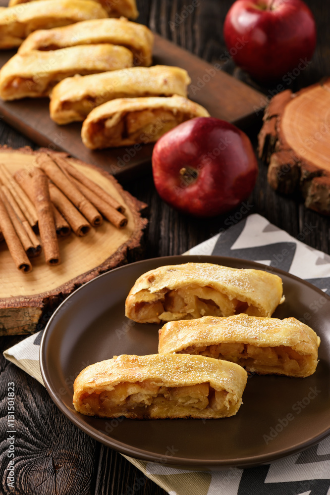 Apple strudel with cinnamon on wooden background. Apple strudel with cinnamon on wooden background.