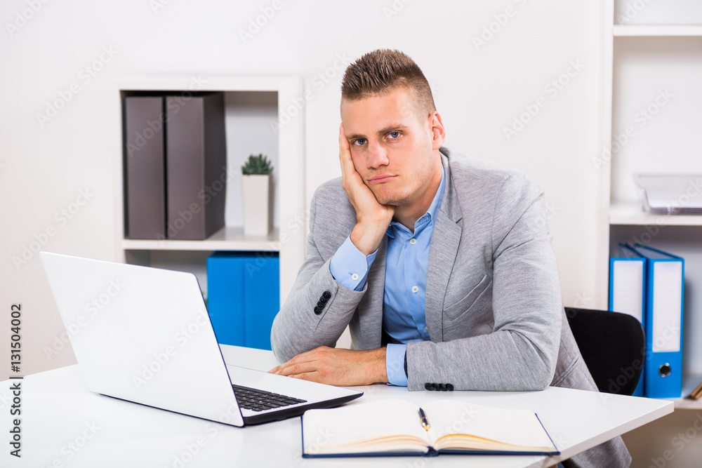Depressed businessman sitting at his office.
Depressed businessman sitting at his office.