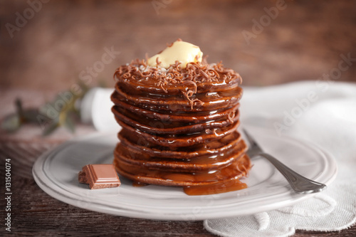 Tasty pancakes with chocolate sauce on plate