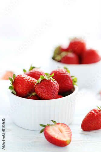 Strawberries in bowl on white wooden table