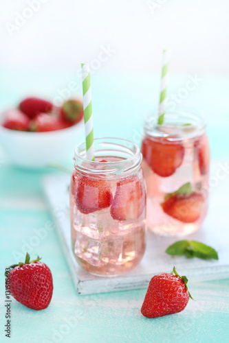 Fresh strawberry drink in bottle on wooden table