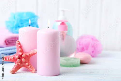 Pink candles with starfish on white wooden table