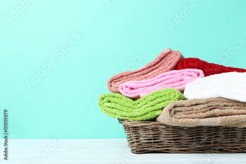 Towels in basket on green background