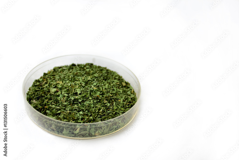 Herbs and seasonings. Dried parsley in a transparent dish isolated on white background. Herbs and seasonings. Dried parsley in a transparent dish isolated on white background.