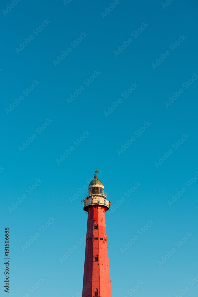Lighthouse over blue sky background with copy space