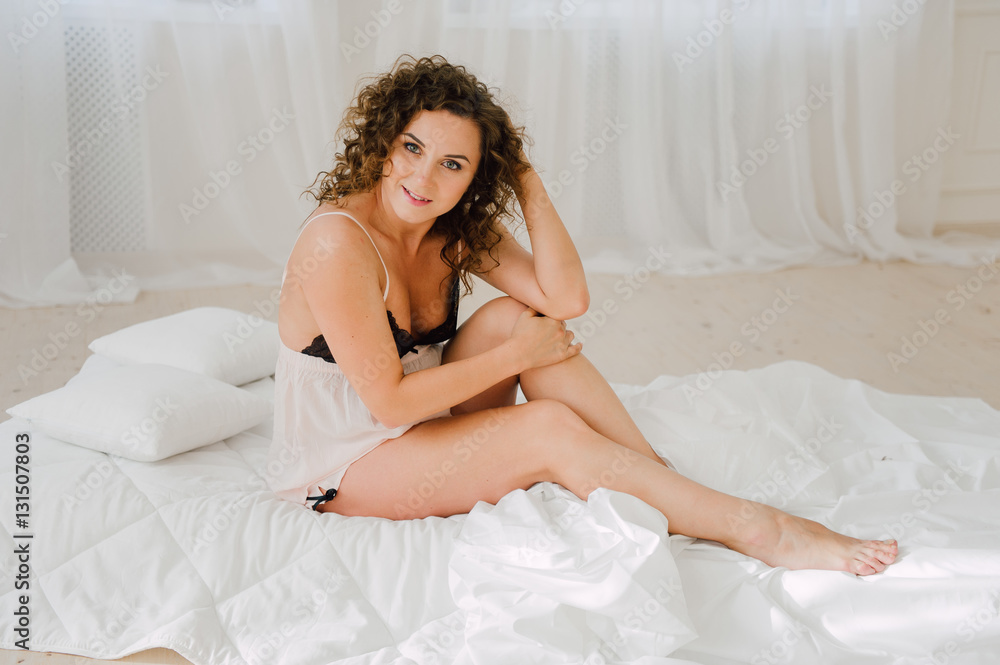 Sexy woman in bed in the morning showing her beautiful body. She doesn't wants to wake up. Awaken with natural light in her bedroom and covered with the bed sheets. Sexy woman in bed in the morning showing her beautiful body. She doesn't wants to wake up. Awaken with natural light in her bedroom and covered with the bed sheets.