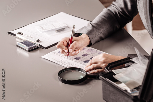 Fotografie Detective expert writes data into the fingerprint  table