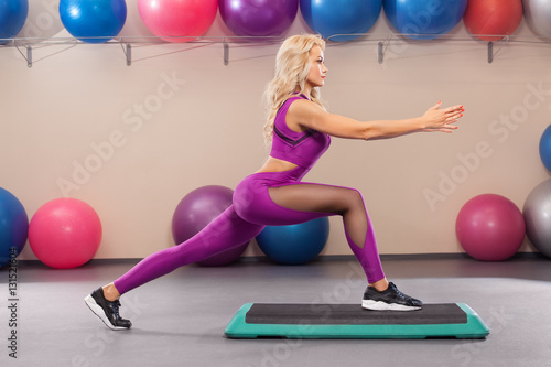 Athletic girl doing stretching exercise in the fitness room. Sport woman in sportswear workout