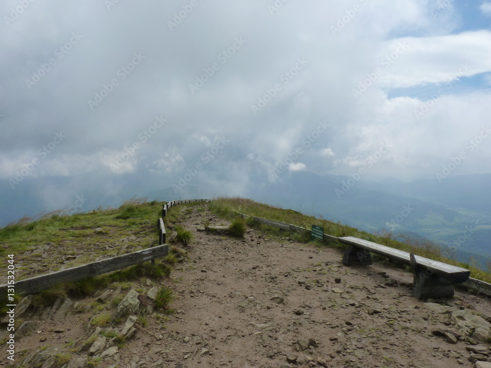 Benches on the top of the mountain. Foggy mountains. The trail in the fog. Beautiful landscape rainy clouds moody weather scenic background. Polonina Carynska, Bieszczady mountains, Poland