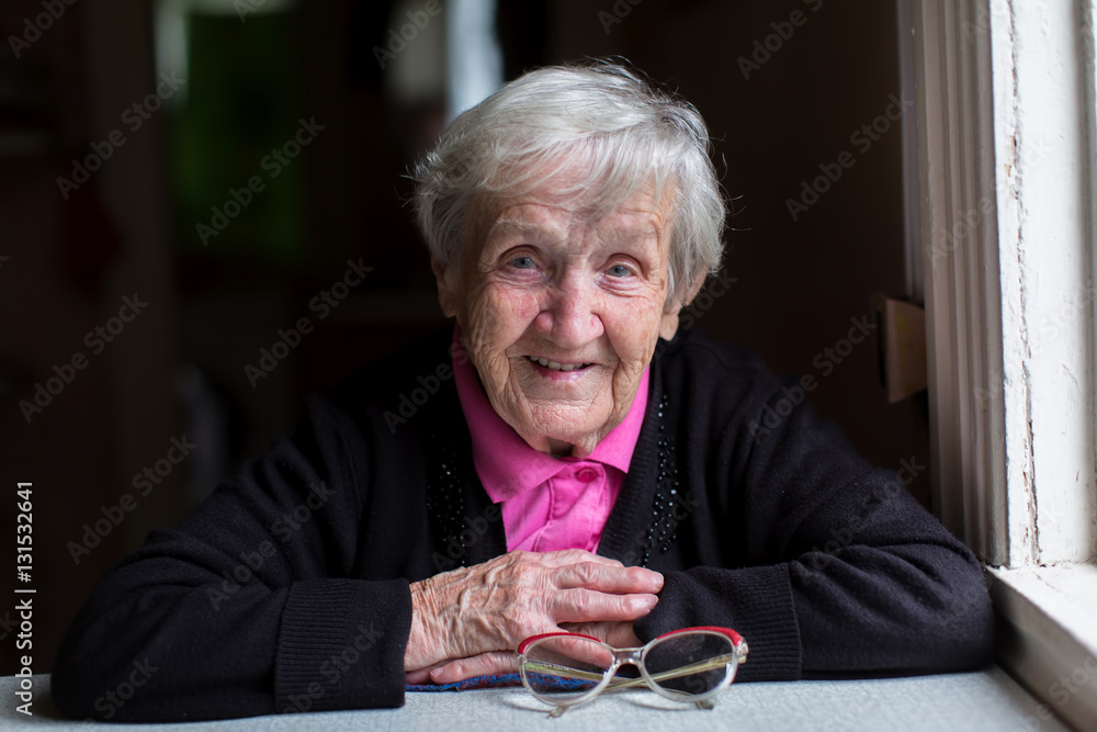 Old woman in her home, looking into the camera... Old woman in her home, looking into the camera...
