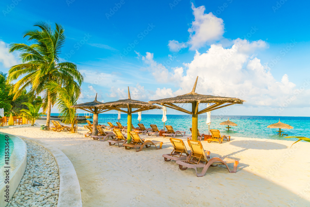Beach chairs with umbrella at Maldives island, white sandy beach