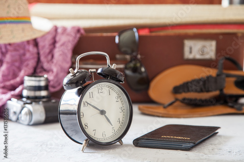alarm clock, documents and things for a holiday in a suitcase, selective focus