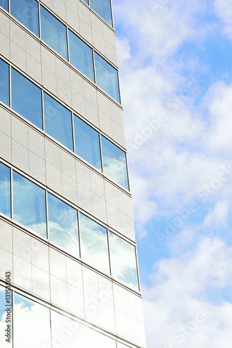 Modern building with clouds & sunshine in vertical frame