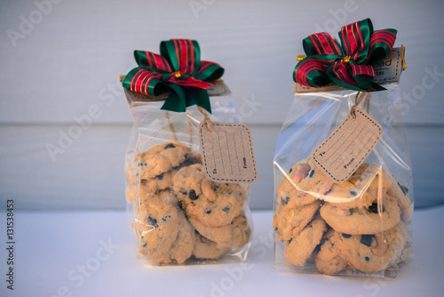 Chocolate cookies in bag on white wooden background.