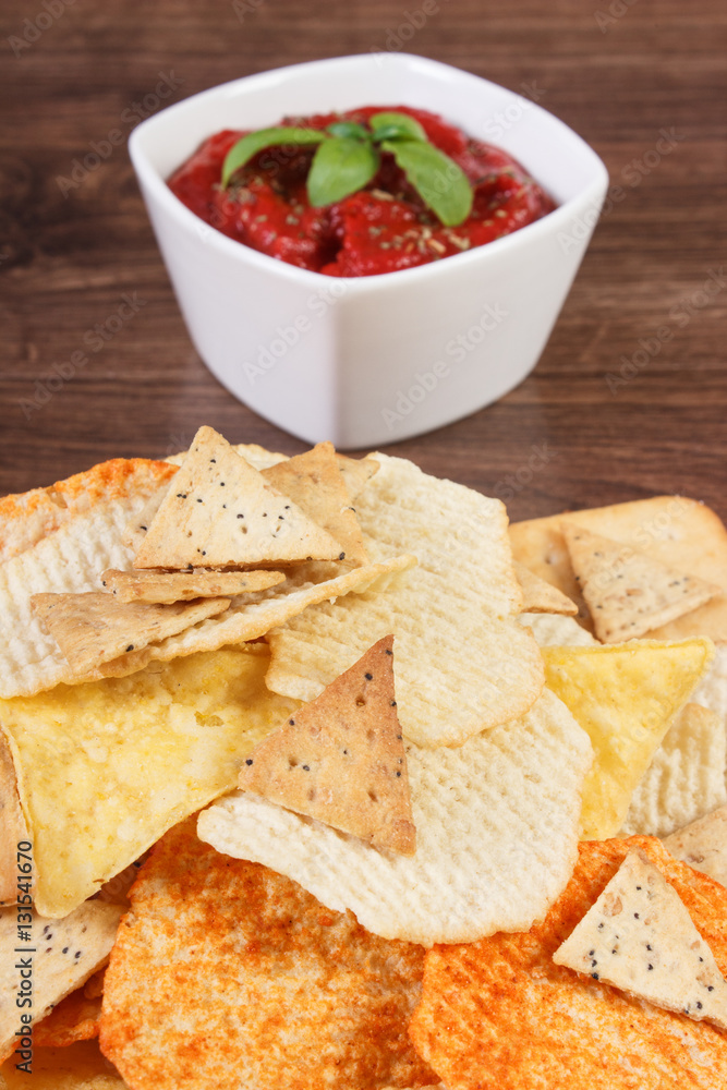 Salted potato crisps, cookies and sauce in bowl, concept of unhealthy food Salted potato crisps, cookies and sauce in bowl, concept of unhealthy food