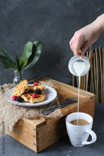 Breakfast waffles with fresh berries stacked on a plate