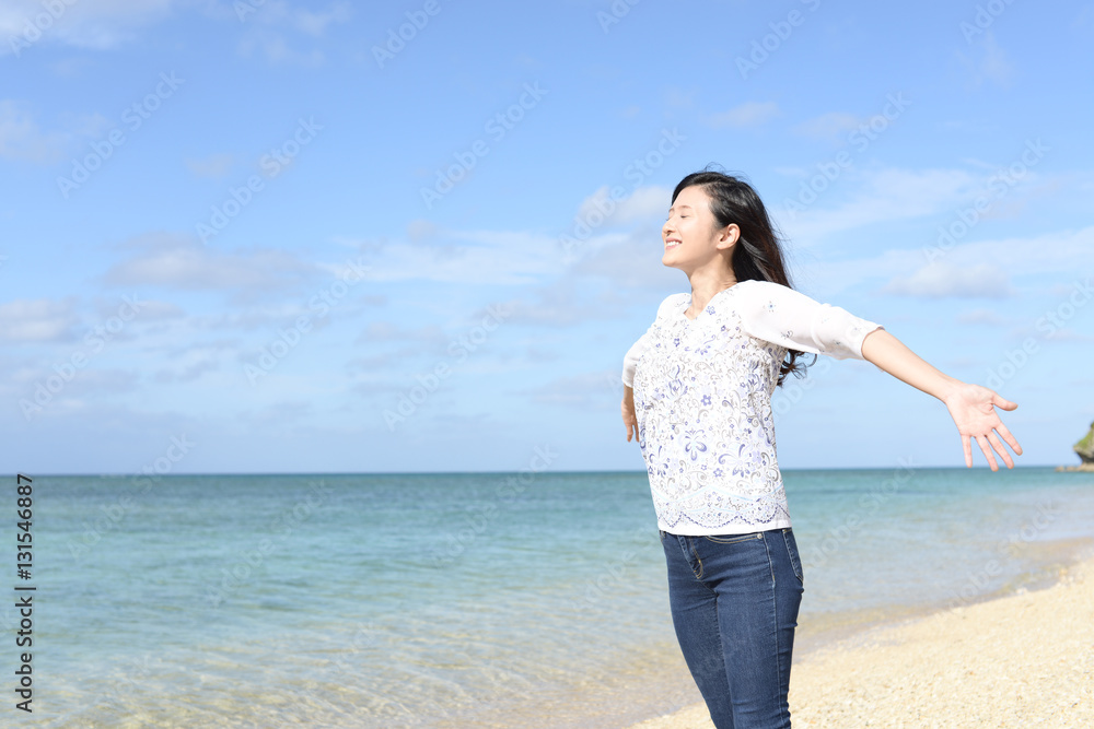 南国沖縄の美しいビーチで寛ぐ女性